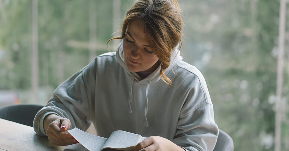 Woman reading her bible and reflecting on the Lord's Prayer